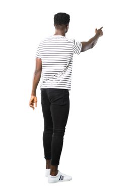 Full body of Dark skinned man with striped shirt pointing back with the index finger presenting a product from behind on white background