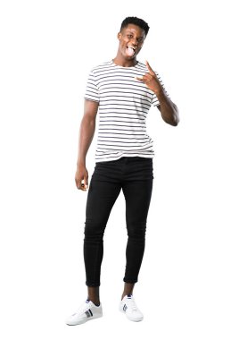 Tam vücut karanlık adam kameraya komik göz olması ve beyaz zemin üzerine boynuzları yaptırmayı dil gösterilen çizgili gömlek ile açık tenli