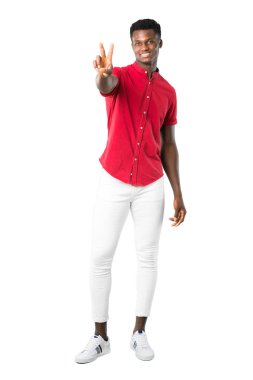 Gülümseyen ve zafer işareti beyaz arka plan üzerinde gösterilen genç Afro-Amerikan insanın tam vücut