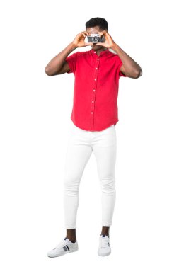 Bir kamera tutarak ve beyaz arka plan üzerinde bir şey çekim Afrikalı-Amerikalı gencin tam vücut