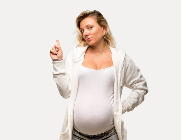 立っていると孤立した灰色の背景上のアイデアを考えて白いトレーナーと金髪妊婦 — ストック写真