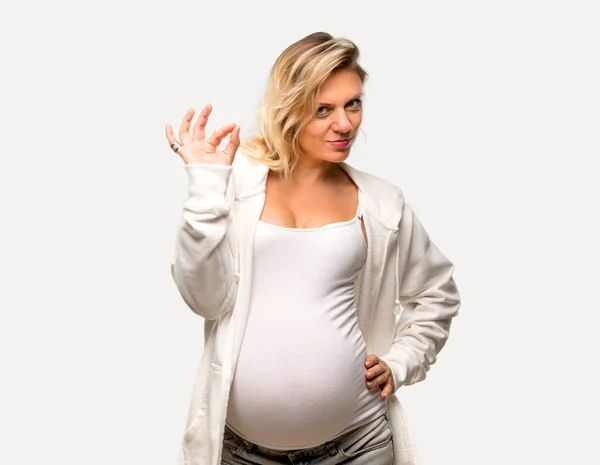 孤立した灰色の背景に指で のサインを示す白いトレーナーと金髪妊婦 — ストック写真