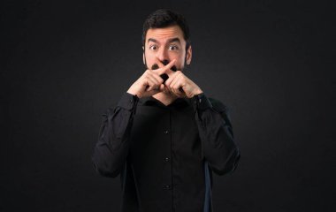 Siyah arka plan üzerine sakal yapma sessizlik hareketi ile yakışıklı adam