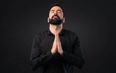 Siyah arka plan üzerine yalvaran sakallı yakışıklı adam