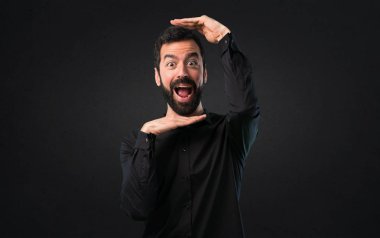 Yüzünü siyah arka plan üzerine odaklanan sakallı yakışıklı adam