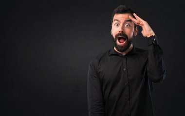 Bir şey siyah arka plan üzerinde gösterilen sakallı yakışıklı adam