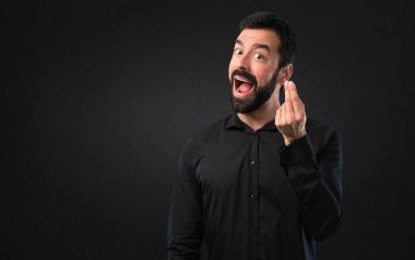 Siyah arka plan üzerine sakal yapma para hareketi ile yakışıklı adam