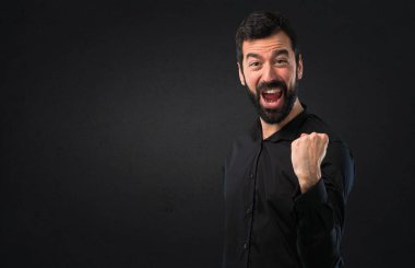Siyah arka plan üzerine sakallı şanslı yakışıklı adam