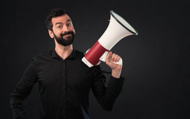 Siyah arka plan üzerine bir megafon tutan sakallı yakışıklı adam