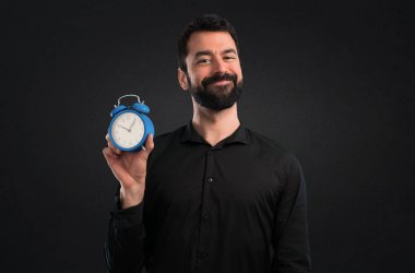 Vintage saat siyah arka plan üzerine tutarak sakallı yakışıklı adam