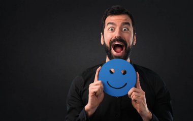 Mutlu yüz simgesi siyah arka plan üzerine tutarak sakallı yakışıklı adam