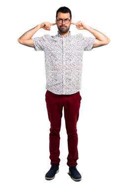 Her iki kulak elleriyle kapsayan gözlüklü yakışıklı adam