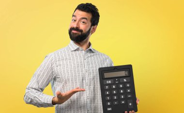 Bir hesap makinesi tutan sakallı yakışıklı adam