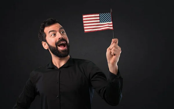 ひげ黒の背景にアメリカの国旗を保持するいるとハンサムな男 — ストック写真