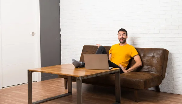 Чоловік Ноутбуком Кімнаті Вказуючи Пальцем Бік Представляючи Продукт — стокове фото