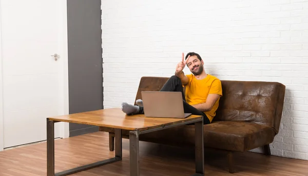 Людина Ноутбуком Кімнаті Посміхається Показує Знак Перемоги — стокове фото