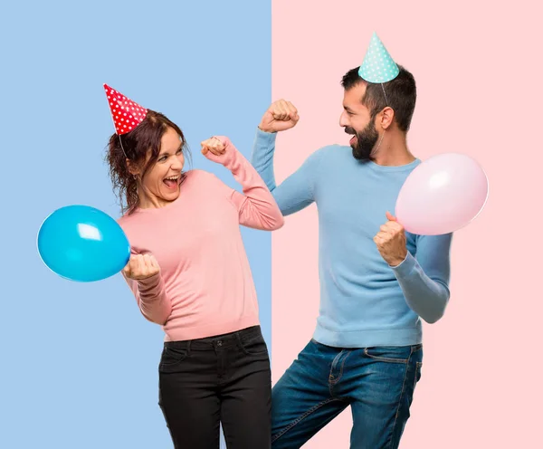 Casal Com Balões Chapéus Aniversário Comemorando Uma Vitória Posição Vencedor — Fotografia de Stock