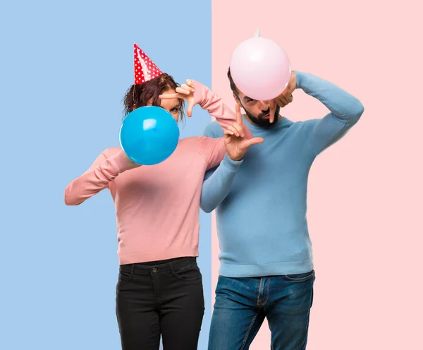 Pareja Con Globos Sombreros Cumpleaños Enfocando Cara Símbolo Encuadre Sobre — Foto de Stock