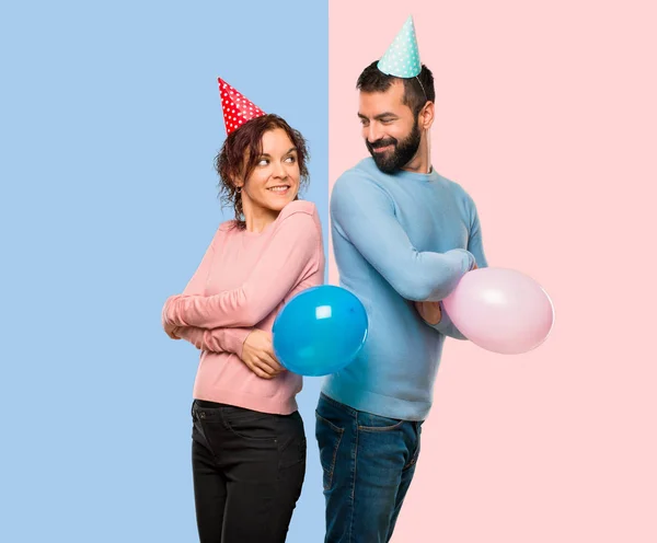 Pareja Con Globos Sombreros Cumpleaños Mirando Por Encima Del Hombro — Foto de Stock