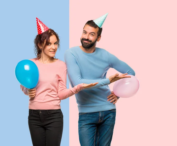 Couple Avec Des Ballons Des Chapeaux Anniversaire Présentant Une Idée — Photo
