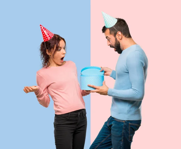 Pareja Con Sombreros Cumpleaños Celebración Regalo Sobre Fondo Rosa Azul —  Fotos de Stock