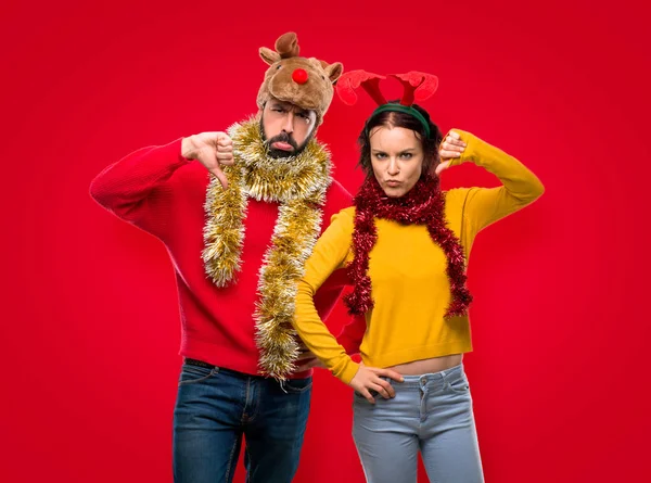 Pár Oblečená Pro Vánoční Svátky Ukazuje Palec Dolů Cedulka Negativní — Stock fotografie