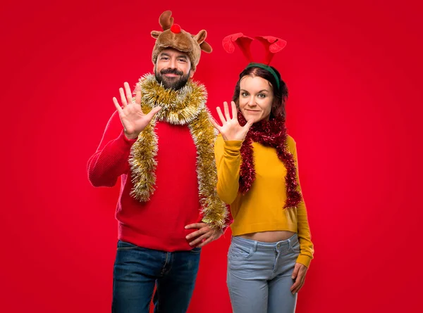 Pár Převlečený Vánoční Svátky Počítání Pět Prsty Izolované Červeném Pozadí — Stock fotografie