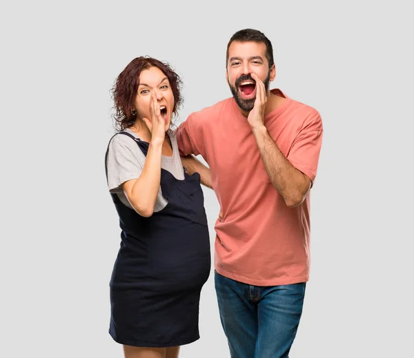 Couple Pregnant Woman Shouting Lateral Announcing Something Isolated Grey Background — Stock Photo, Image