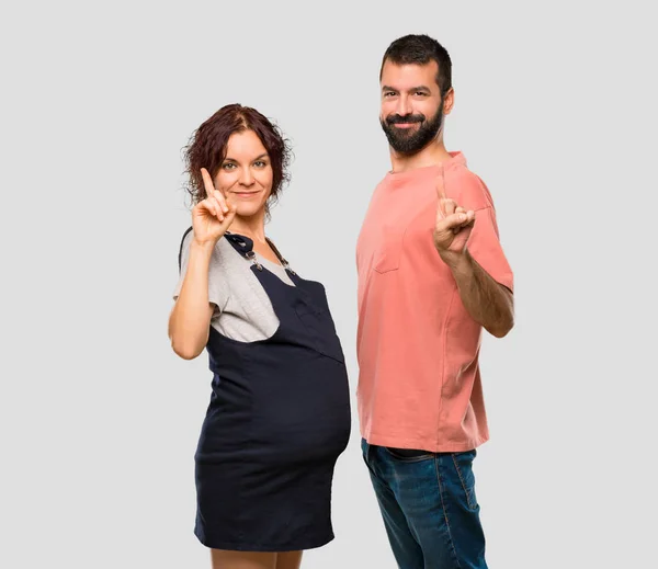 Paar Mit Schwangerer Frau Zeigt Und Hebt Einen Finger Zeichen — Stockfoto