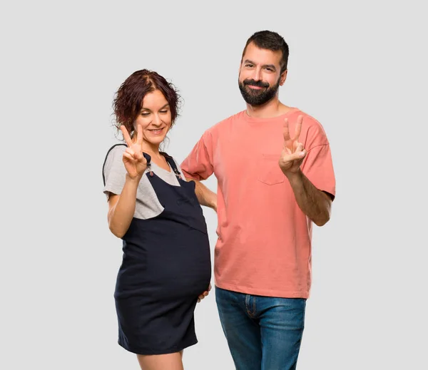 Pár Těhotná Žena Šťastná Počítání Dva Prsty Izolované Šedé Pozadí — Stock fotografie
