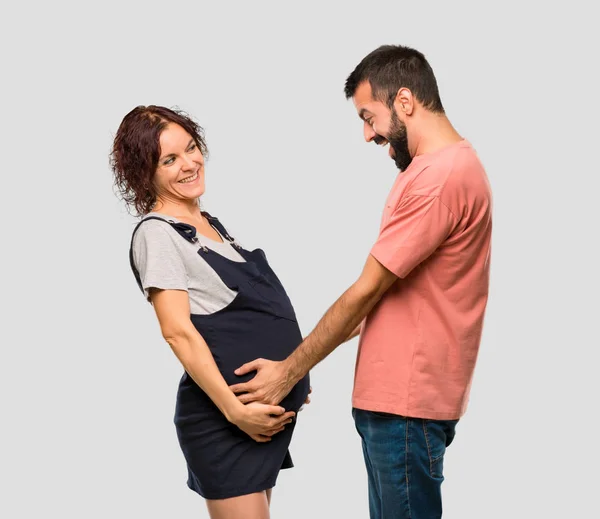 Gelukkige Paar Met Zwangere Vrouw Zoenen Geïsoleerde Grijze Achtergrond — Stockfoto