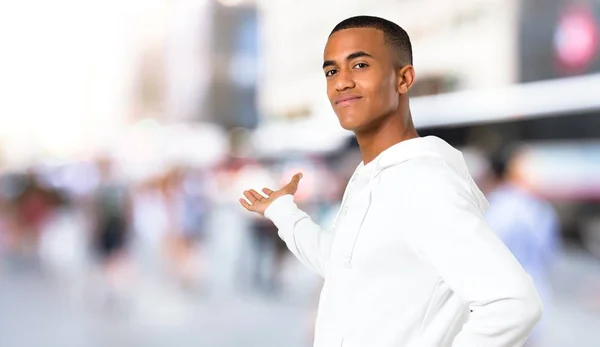 Donkere Jongeman Met Witte Sweatshirt Wijzen Terug Met Wijsvinger Presentatie — Stockfoto