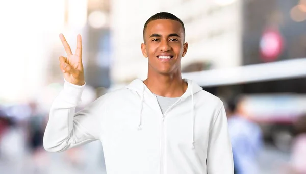 Dark Skinned Young Man White Sweatshirt Smiling Showing Victory Sign — Stock Photo, Image