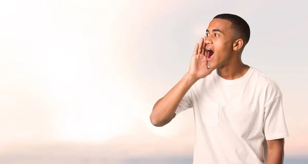 Joven Afroamericano Gritando Con Boca Abierta Hacia Lateral Anunciando Algo — Foto de Stock