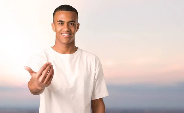 Jovem Afro Americano Apresentando Convidando Para Vir Com Mão Feliz — Fotografia de Stock