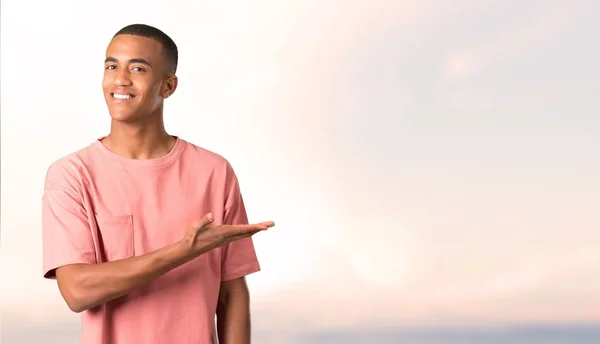 Homem Pele Escura Apresentando Produto Uma Ideia Enquanto Olha Sorrindo — Fotografia de Stock