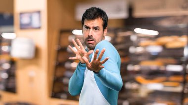 Bir önlük giyen adam biraz gergin ve korkmuş eller için bir fırın ön germe