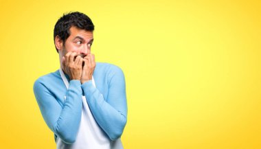 Biraz gergin ve korkmuş koyarak ellerini ağzına sarı zemin üzerine bir önlük giyen biri