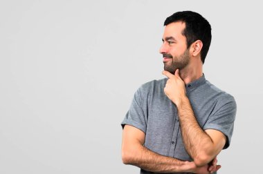 Ayakta ve tarafına gri arka plan üzerinde seyir yakışıklı adam