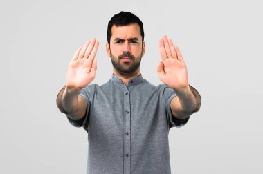 Yakışıklı adam yapma dur jestle elini gri arka plan üzerinde