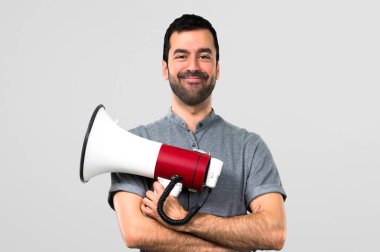 Yakışıklı adam bir megafon gri arka plan üzerinde tutan