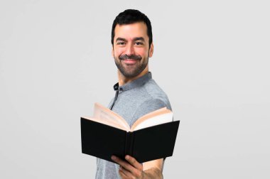 Yakışıklı adam gri arka plan üzerine bir kitap okuma