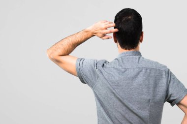 Gri arka plan üzerinde arka pozisyonda yakışıklı adam