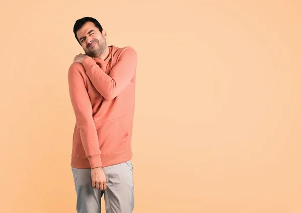 Man Pink Sweatshirt Shoulder Pain Ocher Background — Stock Photo, Image