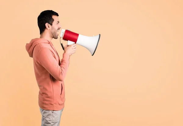 Man Pink Sweatshirt Shouting Megaphone Announce Something Lateral Position Ocher — Stock Photo, Image