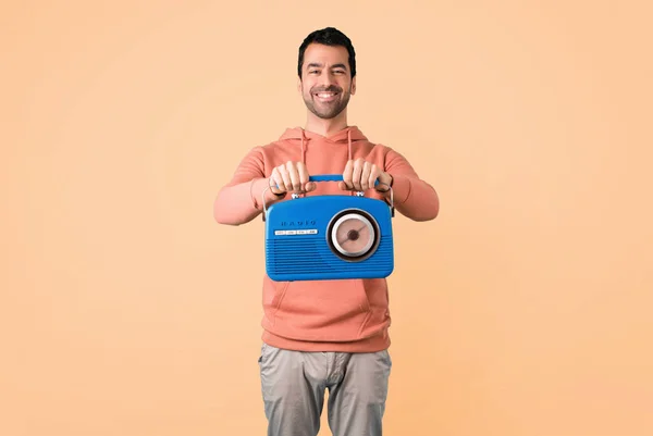 Hombre Con Una Sudadera Rosa Sosteniendo Una Radio Vintage Azul —  Fotos de Stock