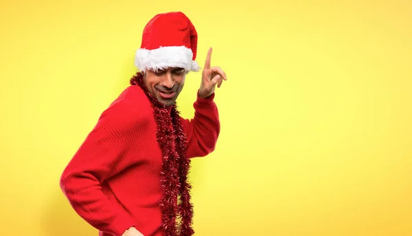 クリスマス休暇を祝う赤い服の男が黄色の背景にパーティーで音楽を聴きながら踊りを楽しむ — ストック写真