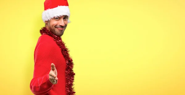 黄色の背景上にかなり後クリスマス休日ハンド シェークを祝う赤い服の男 — ストック写真