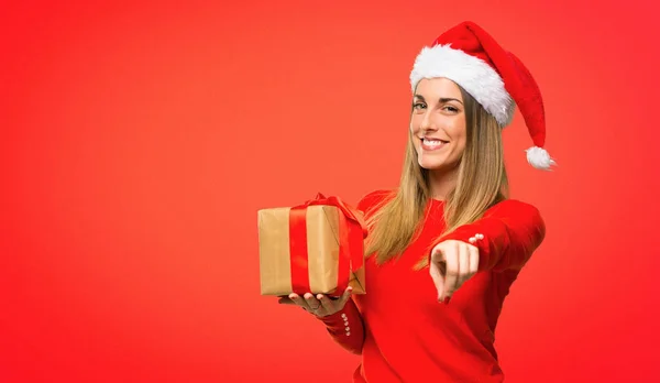 金髪の女性がクリスマス休日ポイント指で赤の背景に自信を持って式のドレスアップ — ストック写真