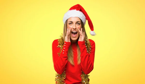 金髪の女性がクリスマス休暇で口を開けて叫びと黄色の背景で何かを発表のドレスアップ — ストック写真